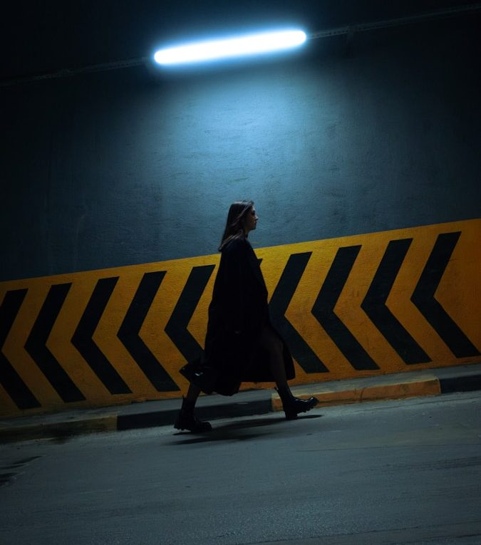 A person walking down a street at night